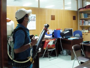 Phun thuốc diệt muỗi các phòng làm việc - Ảnh: THANH ĐẠM